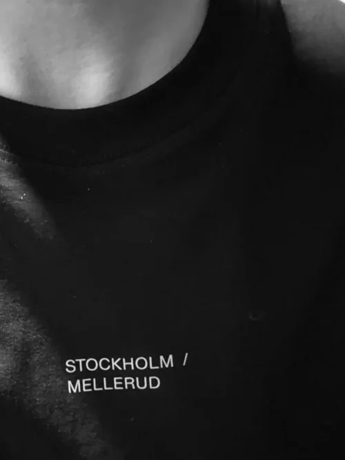 Närbild på svart t-shirt med tryckt brösttext
